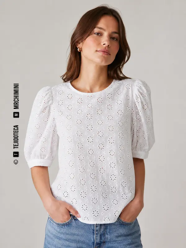Blusa blanca confeccionada con bordado inglés de algodón.