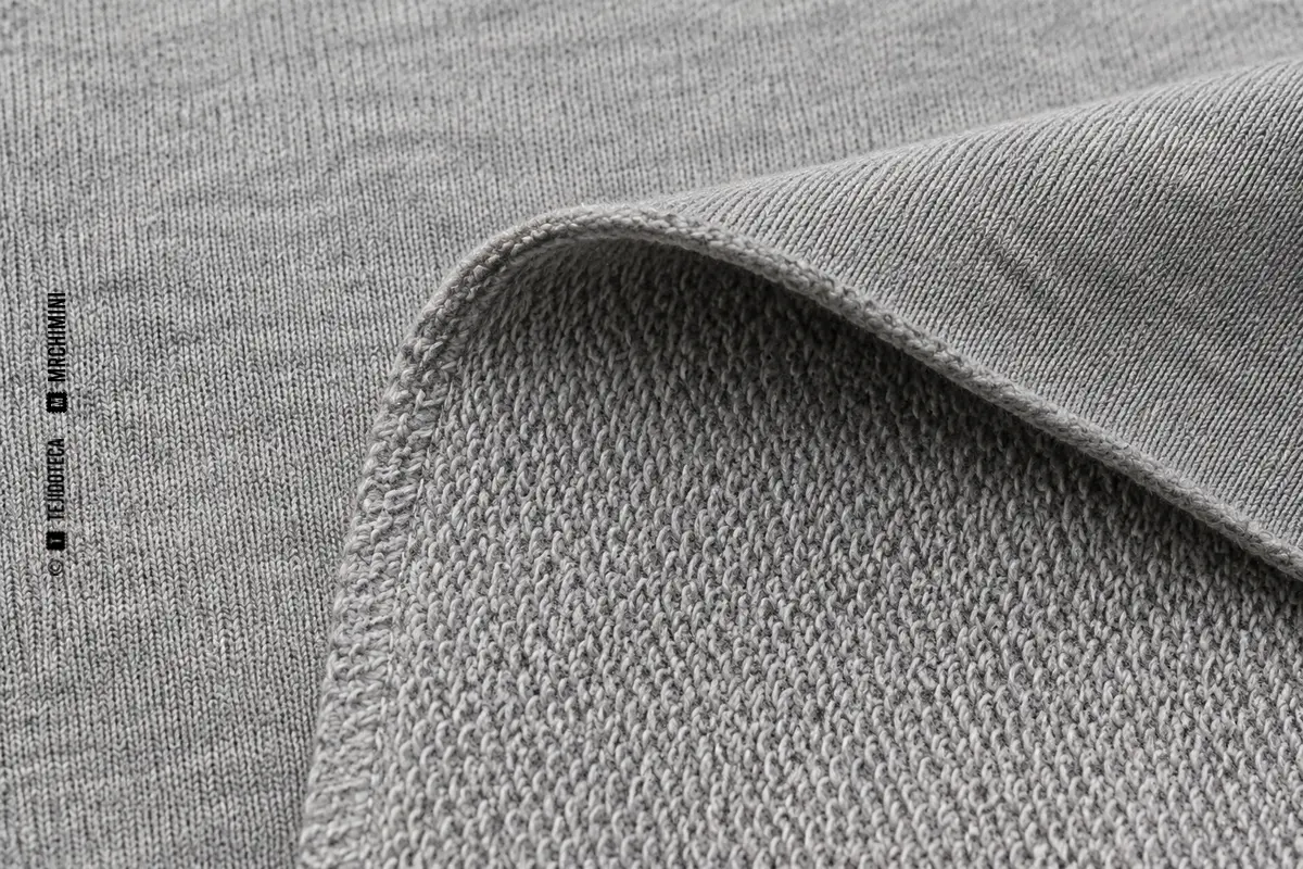 Detalle macro de French terry gris con cara lisa y reverso de bucles sin cortar.