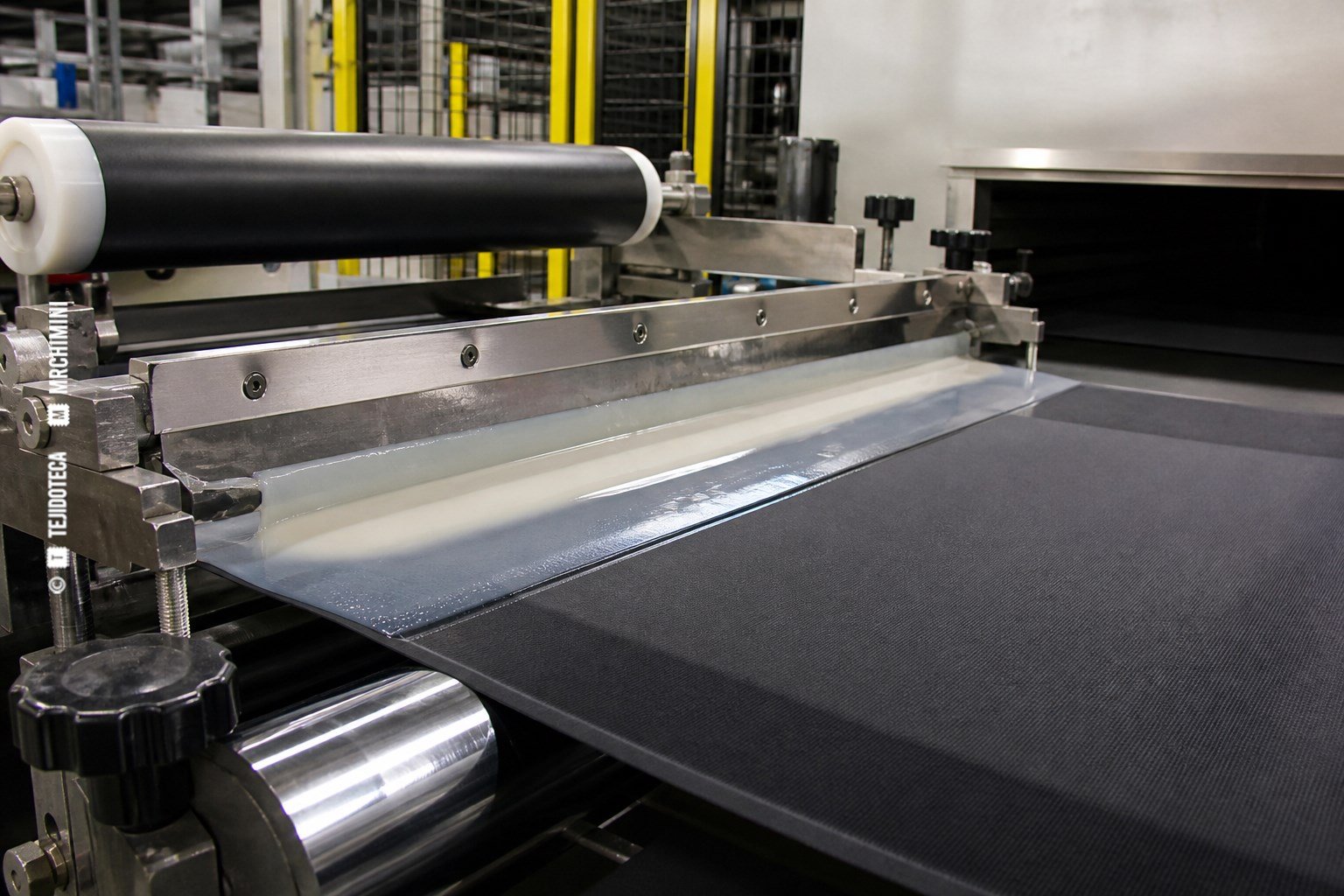 Impermeabilizado — proceso textil Tejido técnico recibiendo una barrera impermeable en una línea industrial