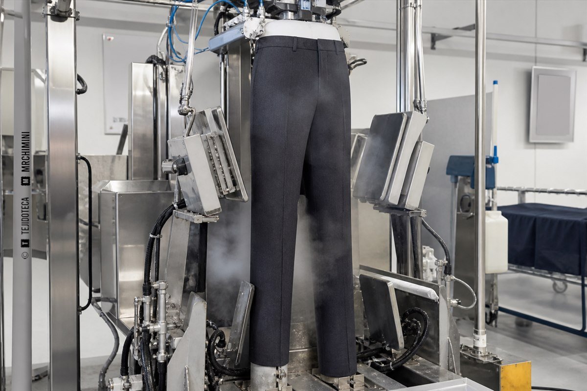 Máquina de planchado de pantalones vaporizando una prenda sujeta por la cintura