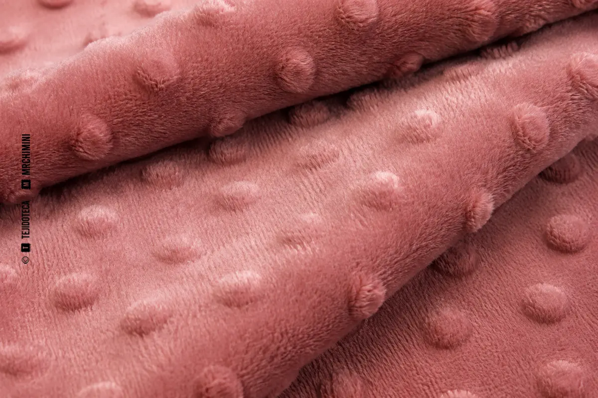 Macro de tejido minky rosa con relieve de puntos