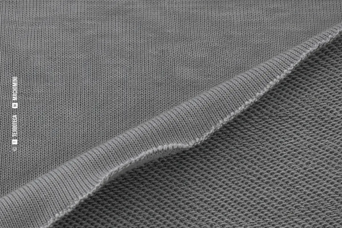 Macrofotografía de punto jersey gris con columnas de mallas visibles