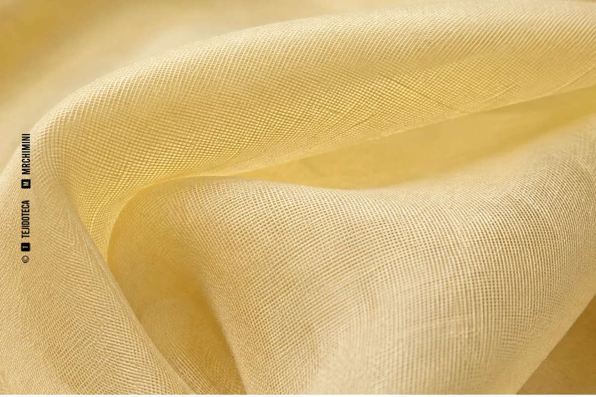Macrofotografía de tejido voile en amarillo mantequilla #E9D48A