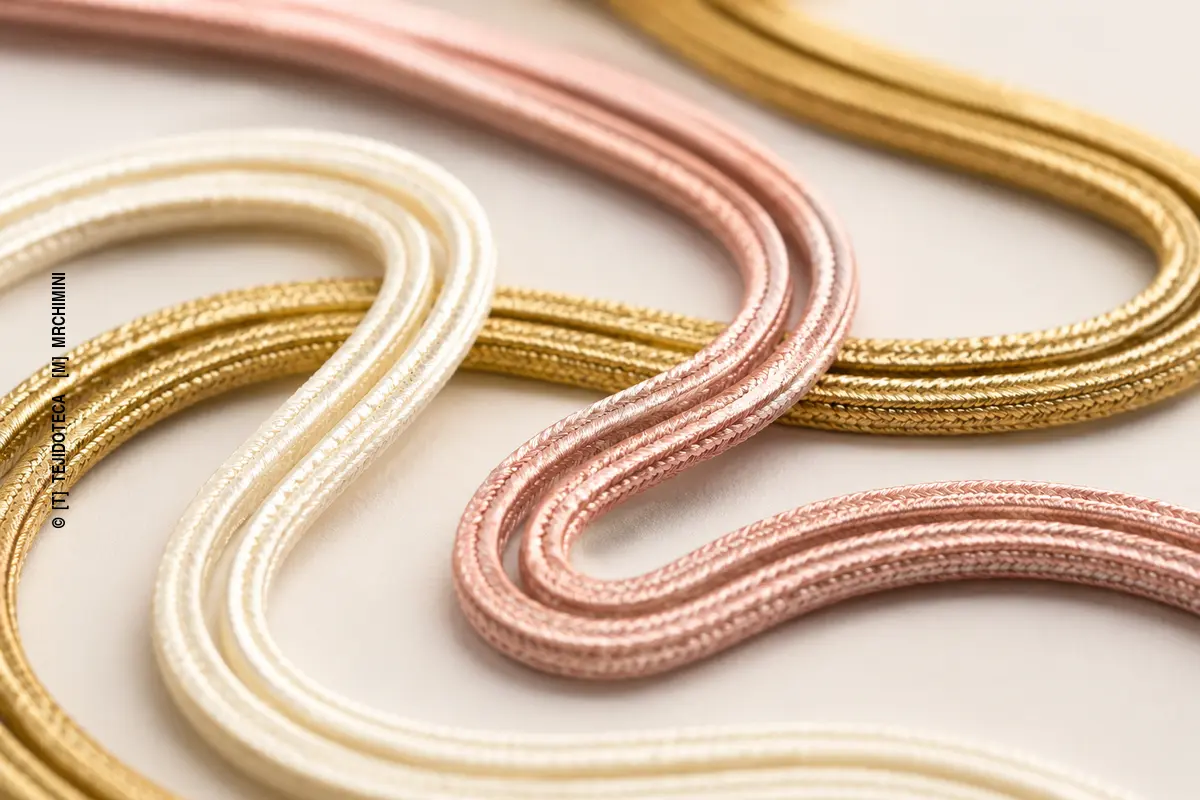 Cordones planos de soutache en curvas suaves donde se distingue el canal longitudinal central.