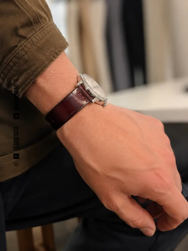 Correa de reloj de cordobán burdeos en la muñeca de una persona