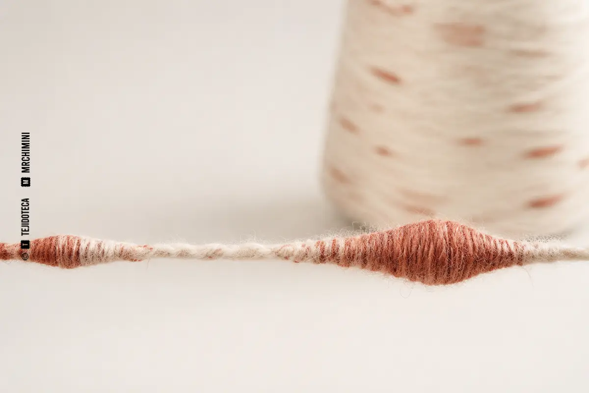Detalle macro de un hilo flamé con tramos finos y gruesos.