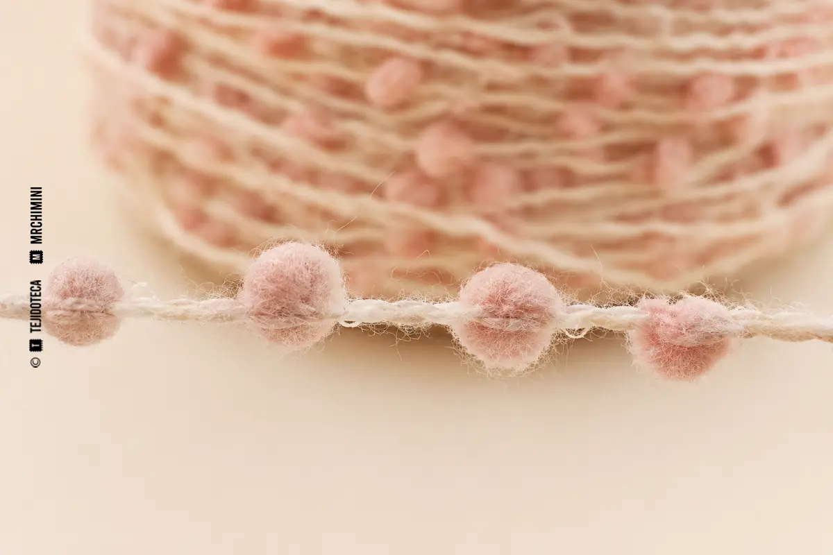 Detalle macro de un hilo Fris con pequeñas bolitas de fibra.