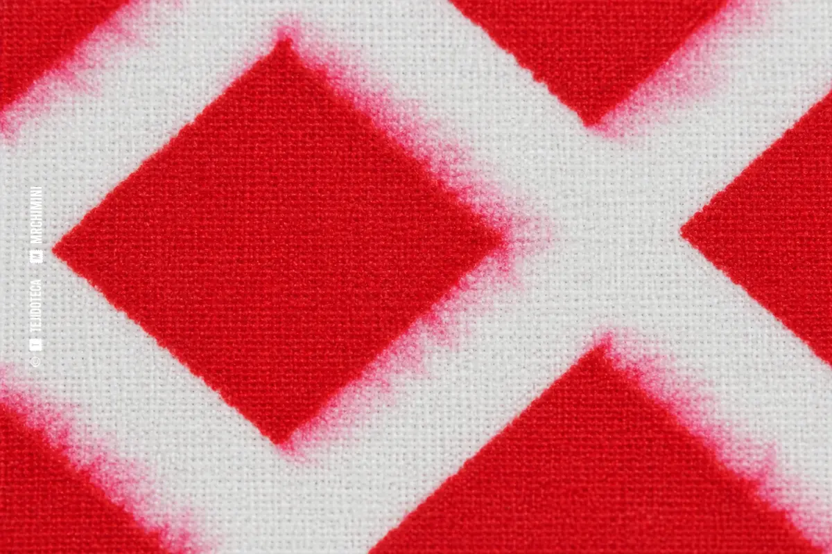 MIGRACIÓN DE COLOR en un tejido estampado rojo con halos rosados fuera de sus contornos