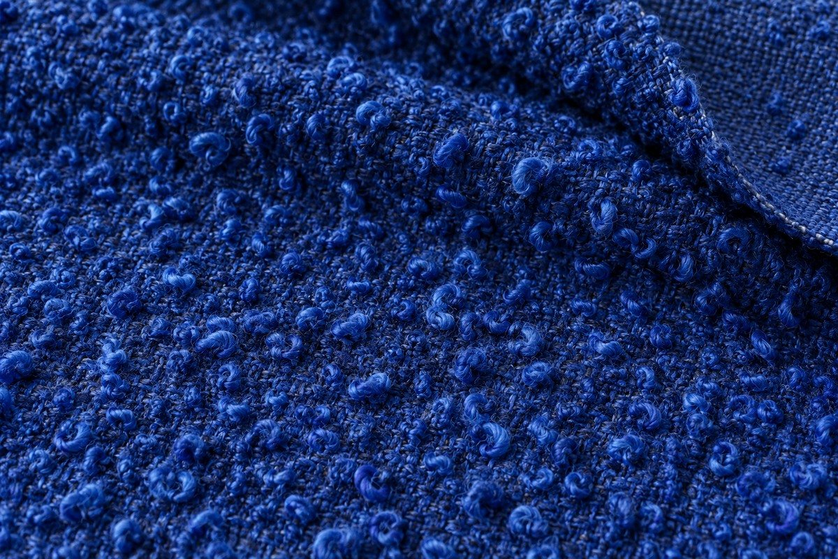 Macro de bouclé azul cobalto con pequeños bucles en los hilos sobre una base tejida visible