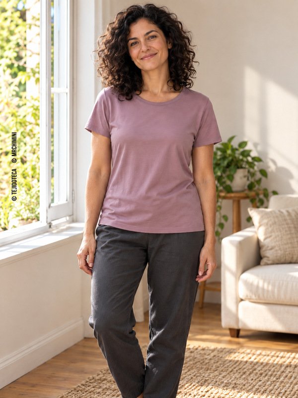 Mujer con camiseta de punto malva de cuello redondo y pantalón gris