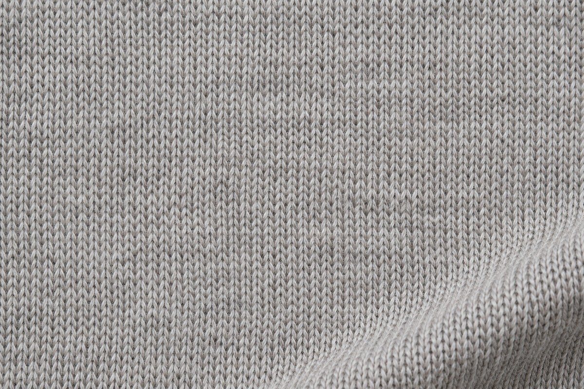 Macro de punto jersey gris claro con pequeñas mallas en V organizadas en columnas