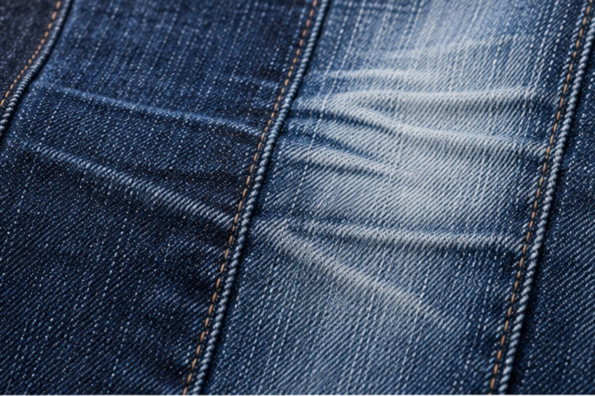 Detalle macro de denim con zonas de índigo desgastadas de forma controlada