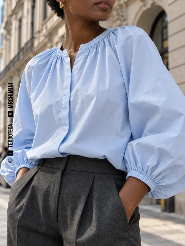 Blusa azul clara con puños fruncidos por una goma oculta en un canal