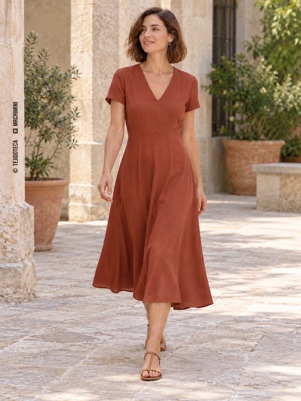 Mujer con vestido midi terracota de manga corta y falda fluida